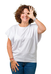 Beautiful middle ager senior woman wearing white t-shirt over isolated background doing ok gesture with hand smiling, eye looking through fingers with happy face.