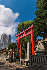 高層マンションと稲荷神社の鳥居