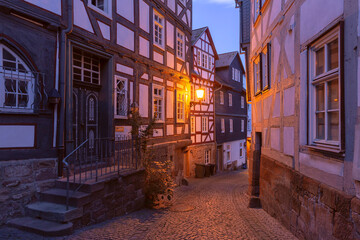A quiet street in Marburg, Germany, showcasing well-preserved half-timbered houses at dusk