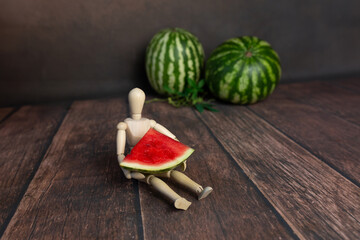 wooden doll man figurine with watermelon on table