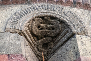 Intricate stone carvings on the Emir Saltuk Tomb in Erzurum, featuring a double-headed dragon with its body intricately knotted, symbolizing power and protection in ancient Turkish mythology.