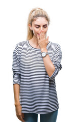 Young beautiful blonde woman wearing stripes sweater over isolated background bored yawning tired covering mouth with hand. Restless and sleepiness.