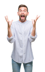 Fototapeta premium Young handsome man over isolated background celebrating crazy and amazed for success with arms raised and open eyes screaming excited. Winner concept