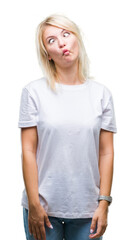Fototapeta premium Young beautiful blonde woman wearing white t-shirt over isolated background making fish face with lips, crazy and comical gesture. Funny expression.