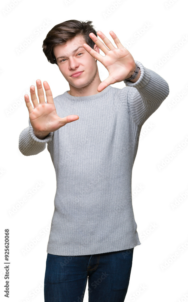 Poster Young handsome man wearing winter sweater over isolated background Smiling doing frame using hands palms and fingers, camera perspective