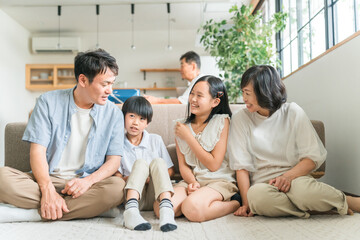 Naklejka premium リビングで団欒するファミリー・三世代家族 