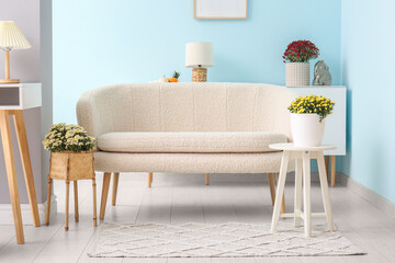 Interior of modern living room with white sofa and beautiful chrysanthemum flowers
