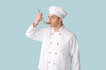 Handsome male chef with ladle on blue background
