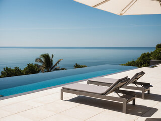 Modern villa terrace with sleek sun beds placed near an infinity pool that merges seamlessly with the horizon.