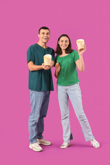 Obraz premium Young couple with french fries on purple background