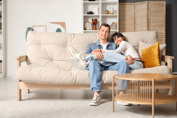 Young couple in love resting on sofa at home