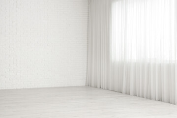 View of empty room with laminate floor and window curtain