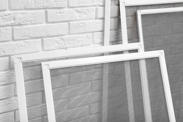 Set of window screens near white brick wall, closeup