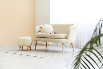 Comfortable sofa with carpet and light curtain in interior of living room