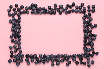Frame made of sweet fresh blueberries on pink background