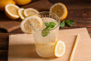 Glass of fresh lemonade with mint on wooden background