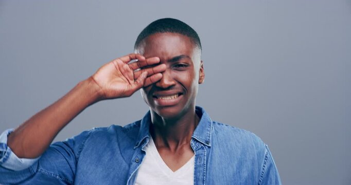 Sad, crying and face of black man in studio with depression, broken heart or expression of emotion. Mental health, portrait and African person with tears for grief, loss or emoji on gray background.