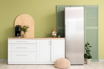 Interior of modern comfortable kitchen with white counter and fridge