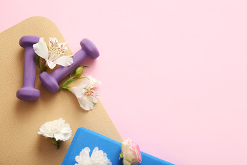 Composition with sports equipment and flowers on pink background