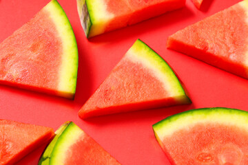 Pieces of sweet watermelon on red background