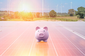 A pink piggy bank is placed on a solar panel, symbolizing savings and investment in renewable energy. Financial planning concept.