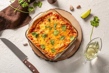 Composition with tasty enchilada and spices on light background