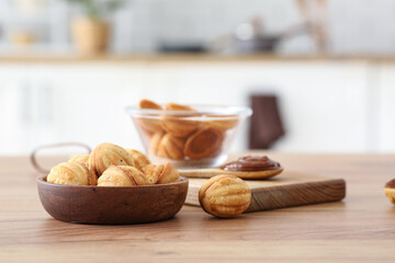 Bowl of tasty walnut shaped cookies with boiled condensed milk on wooden table