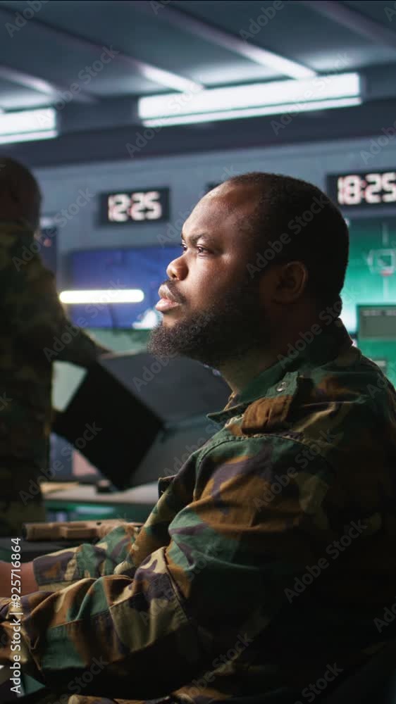 Poster vertical video officer in command center helped by colleague to plan, analyze and gather information