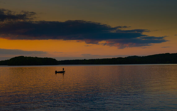 Fishing on a small boat at dusk reflected on Lake Chickamauga, Tennessee