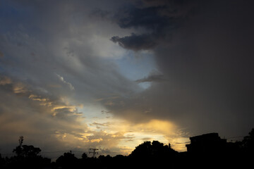 Sunset in the city with dark cloud and light rays on sky