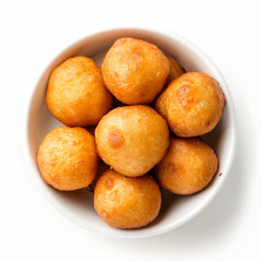 a bowl of fried doughnuts on a white surface