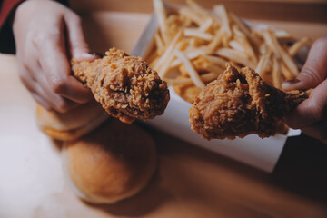 close up focus woman hand hold fried chicken for eat,girl with fast food concept