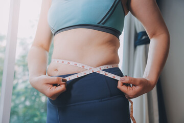 fat woman, fat belly, chubby, obese woman hand holding excessive belly fat with measure tape, woman...