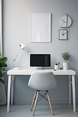 A minimalist home office with a white desk, chair, and computer, framed picture, and a plant.