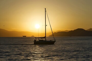 Boat silhouette at sunlight in sea