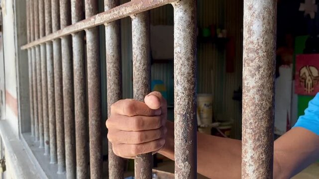 close up of prisoner hands in jail background.