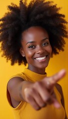 Delighted cheerful Afro American woman with crisp hair, points away