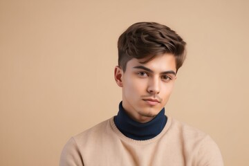 Obraz premium Portrait of a young man with brown hair and a beige sweater
