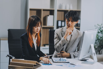 Entrepreneur Asian businessman and businesswoman discussing new business project in tablet in modern Meeting In Modern Office, Asian business casual concept.