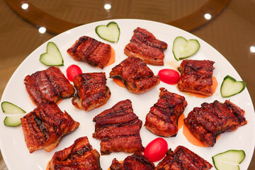 close up of Japanese sliced grilled ox beef tongue on a blush green plate with cabbage and cherry tomato on the side