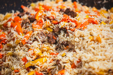 Uzbek pilaf cooked in a cauldron over a fire