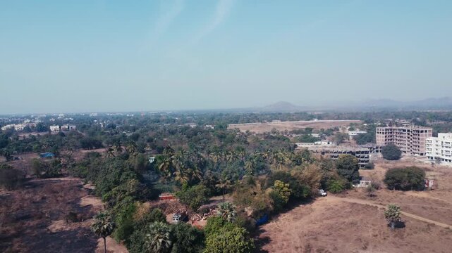 Rural landscape with scattered buildings under clear blue sky, aerial view