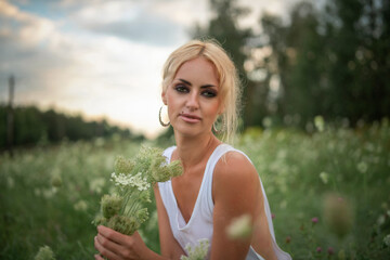 Portrait of a young beautiful blonde green-eyed girl in nature.