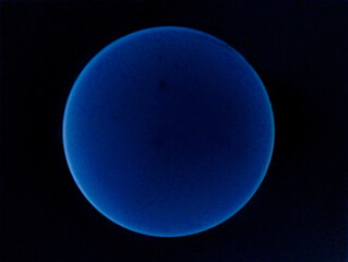 Luminous blue sphere against a dark background, resembling a celestial body, image stock photo 
