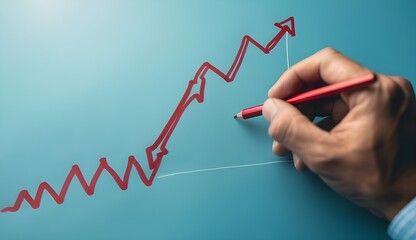 Businessman drawing a red arrow pointing down on a graph trending downward.