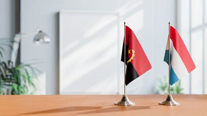 FLAGS OF ANGOLA AND LUXEMBOURG  ON TABLE