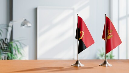 FLAGS OF ANGOLA AND MONTENEGRO  ON TABLE