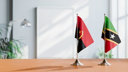 FLAGS OF ANGOLA AND SAINT KITTS ON TABLE