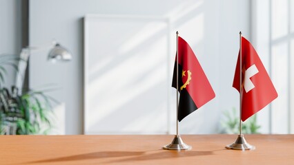 FLAGS OF ANGOLA AND SWITZERLAND  ON TABLE