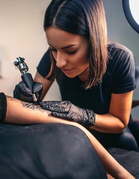 Una tatuadora profesional, realizando un tatuaje; arte